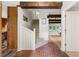 Open hallway featuring brick floor, wooden beams, staircase, and access to other rooms at 4018 Dunbarton Ne Way, Roswell, GA 30075