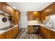 Kitchen featuring wooden cabinets, marble countertops, stainless steel appliances, and vinyl floors at 4018 Dunbarton Ne Way, Roswell, GA 30075