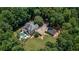 Aerial view of a home with a pool, surrounded by lush greenery and a detached garage at 110 Wellington Way, Canton, GA 30115