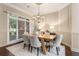 Cozy dining room with modern chandelier, hardwood floors, and lots of light from the windows at 110 Wellington Way, Canton, GA 30115