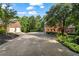 Long driveway leads to a brick house with a two-car detached garage amidst lush landscaping at 110 Wellington Way, Canton, GA 30115