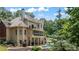 Back of house with a two story screened in porch and a pool in a backyard oasis at 110 Wellington Way, Canton, GA 30115