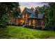 Charming two-story brick home with manicured lawn, mature trees, and warm lighting at sunset at 110 Wellington Way, Canton, GA 30115