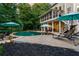 Backyard pool area with mature trees, outdoor seating, and attached elevated screened porch at 110 Wellington Way, Canton, GA 30115