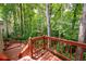 Stairs lead down to the wooden deck, surrounded by an oasis of mature trees and greenery at 313 Clubhouse Nw Ct, Kennesaw, GA 30144