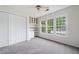 Bright bedroom featuring neutral walls and carpet, built in shelves, desk, and windows with outside views at 313 Clubhouse Nw Ct, Kennesaw, GA 30144