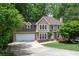 Beautiful two-story house with lush greenery, including trees surrounding the well manicured lawn, and a spacious driveway at 313 Clubhouse Nw Ct, Kennesaw, GA 30144