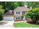 Charming two-story home featuring a well-manicured lawn, two-car garage, and a welcoming stone-accented entrance at 313 Clubhouse Nw Ct, Kennesaw, GA 30144