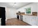 Kitchen featuring all-white cabinetry, dark appliances, hardwood floors, and a view into the backyard at 313 Clubhouse Nw Ct, Kennesaw, GA 30144