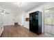 Large kitchen featuring all-white cabinetry, dark appliances, hardwood floors, and views into other rooms at 313 Clubhouse Nw Ct, Kennesaw, GA 30144