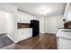 Kitchen featuring all-white cabinetry, dark appliances, hardwood floors, and a view into another room at 313 Clubhouse Nw Ct, Kennesaw, GA 30144