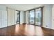 Bright bedroom featuring hardwood floors, large windows with a view, and two doors at 3481 Lakeside Ne Dr # 1107, Atlanta, GA 30326
