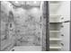 Walk-in shower featuring gray marble tile, a rainfall shower head, and linen storage at 505 Whitehall Sw St # 102, Atlanta, GA 30303