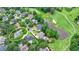Aerial view of a home on the golf course surrounded by trees and a pond at 5980 Whitestone Ln, Suwanee, GA 30024