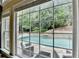 A view of the backyard pool and patio area through a large window at 5980 Whitestone Ln, Suwanee, GA 30024