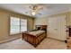 Bedroom featuring a window with blinds, ceiling fan, and a double door closet at 5980 Whitestone Ln, Suwanee, GA 30024