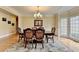 Classic dining room featuring a chandelier, hardwood floors, and large windows for natural light at 5980 Whitestone Ln, Suwanee, GA 30024