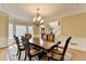 Well-lit dining room featuring hardwood floors, a chandelier, and access to other rooms in the home at 5980 Whitestone Ln, Suwanee, GA 30024