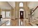 Grand foyer with hardwood floors, a staircase, and a front door with an oval glass insert at 5980 Whitestone Ln, Suwanee, GA 30024