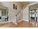 Light-filled foyer with hardwood floors, a staircase, and an open view into other rooms of the house at 5980 Whitestone Ln, Suwanee, GA 30024