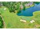 Aerial view of a well-manicured golf course bordering a pond and lined with mature trees at 5980 Whitestone Ln, Suwanee, GA 30024