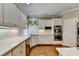 Modern kitchen with white cabinets, stainless steel appliances, and hardwood floors at 5980 Whitestone Ln, Suwanee, GA 30024