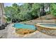 Backyard oasis featuring a private pool, hot tub, and mature trees at 5980 Whitestone Ln, Suwanee, GA 30024
