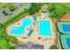 Aerial view of a resort-style pool area with ample seating, tennis courts, and mature trees offering refreshing shade at 5980 Whitestone Ln, Suwanee, GA 30024
