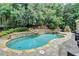 Inviting backyard pool with stone accents, a water feature, and a built-in fireplace for outdoor enjoyment at 5980 Whitestone Ln, Suwanee, GA 30024