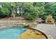 Custom pool area with waterfall features, a spa, fireplace, and lush landscaping at 5980 Whitestone Ln, Suwanee, GA 30024