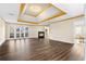 Living room features a fireplace, tray ceiling, wood floors, and french doors to a patio at 971 Ashebrooke Ne Ct, Marietta, GA 30068