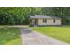 The house has a long driveway, surrounded by greenery and a well-manicured lawn at 525 Baker Nw Cir, Atlanta, GA 30318