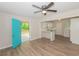 Open-concept living area with modern ceiling fan, wood floors, and a bright turquoise front door at 525 Baker Nw Cir, Atlanta, GA 30318