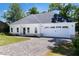 Charming single-story home with a white exterior, a gray roof, and a paver driveway at 614 Glendale Rd, Scottdale, GA 30079