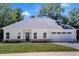 Charming single-story home with a white exterior, a gray roof, and an attached two-car garage at 614 Glendale Rd, Scottdale, GA 30079