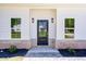 Close-up of a modern front door flanked by elegant sconces and trimmed by light brick at 614 Glendale Rd, Scottdale, GA 30079