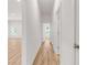 Hallway with hardwood floors, white walls, and multiple doorways at 614 Glendale Rd, Scottdale, GA 30079