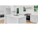 Bright kitchen showcasing an island with stainless steel appliances and white cabinetry at 614 Glendale Rd, Scottdale, GA 30079