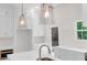 Bright, white kitchen with pendant lights, stainless steel appliances, and hardwood floors at 614 Glendale Rd, Scottdale, GA 30079