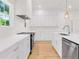 White kitchen featuring stainless steel appliances, an island, and hardwood floors at 614 Glendale Rd, Scottdale, GA 30079