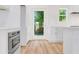 Bright, white kitchen with stainless steel appliances, and hardwood floors at 614 Glendale Rd, Scottdale, GA 30079