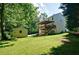 Side view of house showing a backyard, shed, and stairs leading to a deck, surrounded by mature trees at 809 Longbranch Ln, Douglasville, GA 30134