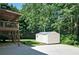 View of a backyard featuring a storage shed and elevated deck with stairs on a property with lush trees at 809 Longbranch Ln, Douglasville, GA 30134