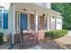 Inviting front porch with brick columns, blue door, and decorative hanging plants at 809 Longbranch Ln, Douglasville, GA 30134