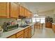 Open kitchen area with wooden cabinets, ample counter space, stainless steel sink and view to dining room at 809 Longbranch Ln, Douglasville, GA 30134