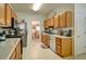 Functional kitchen with wooden cabinetry, stainless steel appliances, and a view into the adjacent dining space at 809 Longbranch Ln, Douglasville, GA 30134