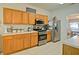Spacious kitchen features wooden cabinets, stainless steel appliances, and views of an adjacent dining area at 809 Longbranch Ln, Douglasville, GA 30134