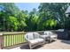 Outdoor deck features wicker furniture, a grill, and beautiful tree views at 395 Grove Ridge Dr, Loganville, GA 30052
