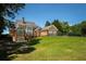 Expansive backyard featuring a spacious deck, brick exterior, and well-maintained lawn at 395 Grove Ridge Dr, Loganville, GA 30052