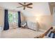 Bright bedroom featuring a ceiling fan, a window and cozy furnishings at 395 Grove Ridge Dr, Loganville, GA 30052